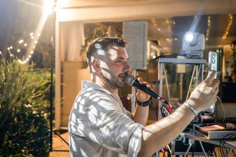 Uomo con il cellulare alla cabina del DJ
