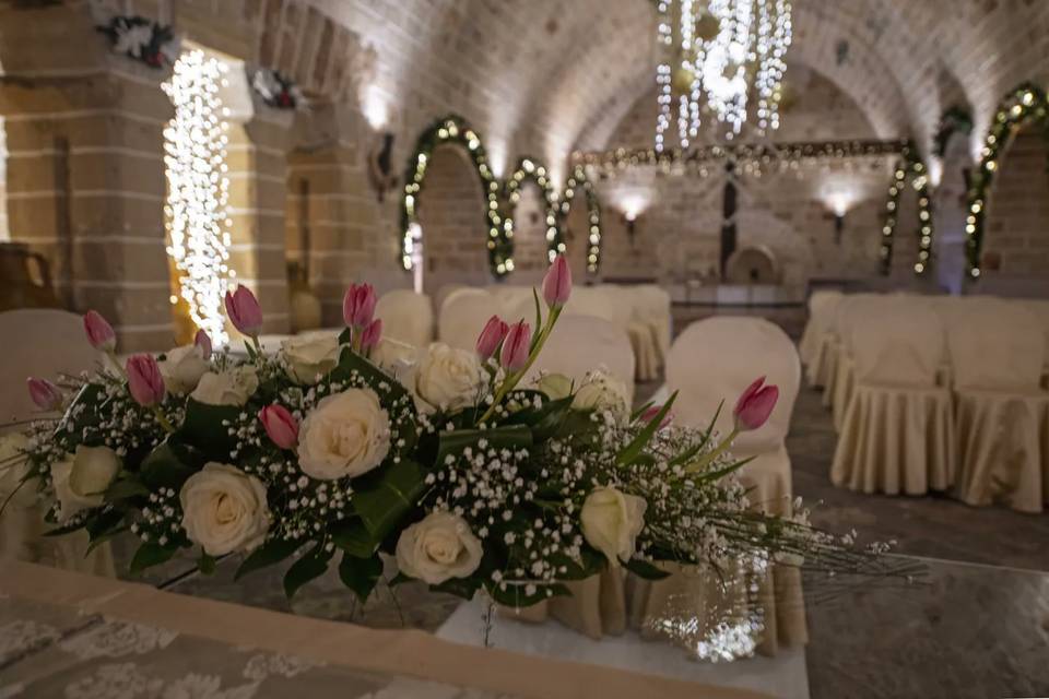 Rose bianche e tulipani rosa sul tavolo degli sposi