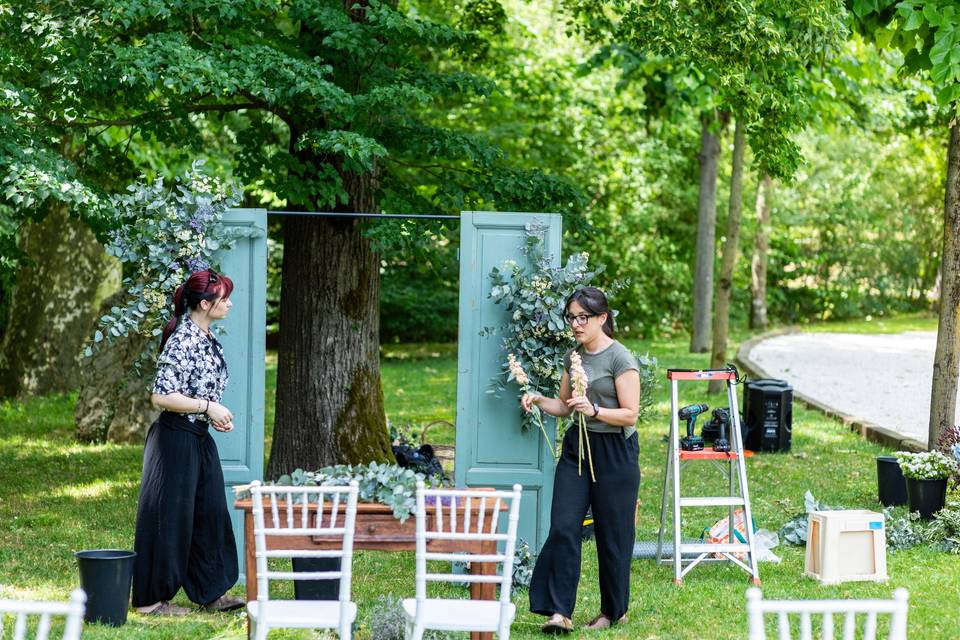 Due donne che decorano arco floreale