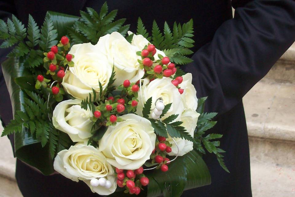 Bouquet tondo con rose bianche, hypericum rosso e foglie di felece e aspidistria