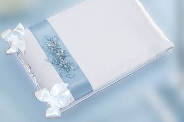 Guestbook rivestito in raso bianco con applicazione raso azzurro soggetto fiori a scelta e fiocchetti in raso bianco