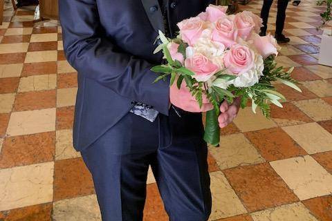Lo sposo ammira il bouquet